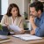 Insurance consultant discussing documents with a client in an office