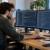 IT consultant working at a computer with multiple screens and software